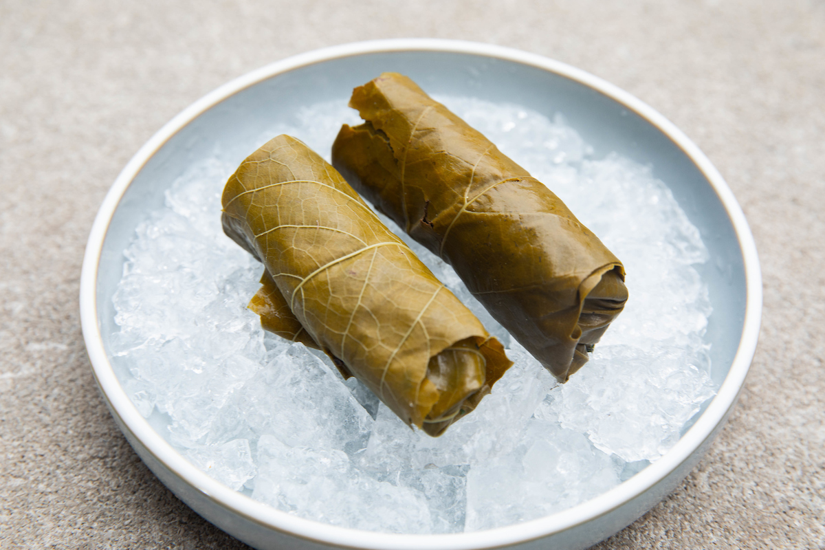 grape leave rolls on a white serving dish